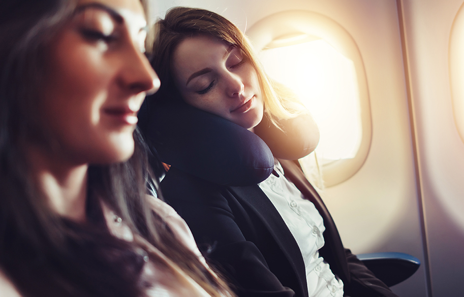 foolproof-ways-to-sleep-on-a-plane-women-getting-comfortable-on-an-airplane